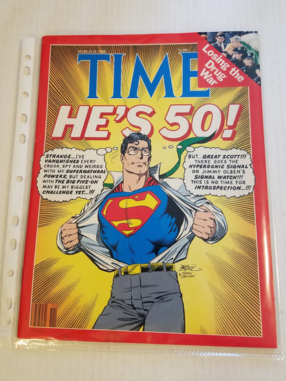A vintage Time comic book cover featuring Superman with the headline 'HE'S 50!' and a red 'TIME' logo, photographed inside a clear plastic sleeve on a white surface.